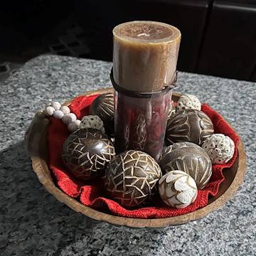 Decorative carved mango wooden balls on a bowl